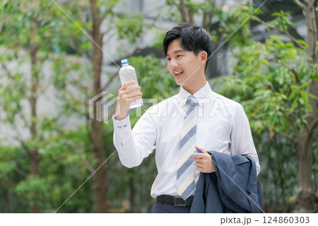 公園で水を飲むサラリーマン 公園で水を飲むサラリーマン 124860303