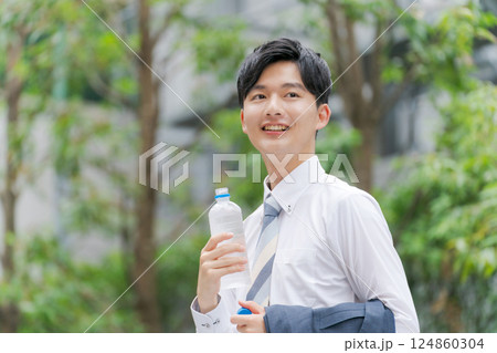 公園で水を飲むサラリーマン 124860304