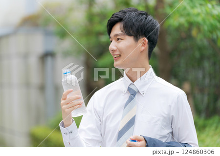 公園で水を飲むサラリーマン 124860306
