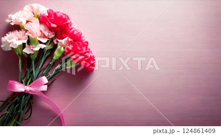 ピンクの背景にカーネーションの花束。母の日のイメージ。感謝の気持ちを表す。	 124861409
