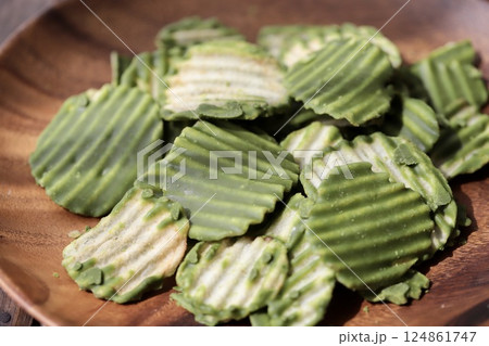 アカシアプレートに乗せたギザギザカットの抹茶チョコポテトチップス アカシアプレートに乗せたギザギザカットの抹茶チョコポテトチップス 124861747