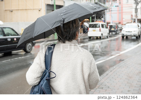 雨の中、傘をさすシニア男性 雨の中、傘をさすシニア男性 124862364