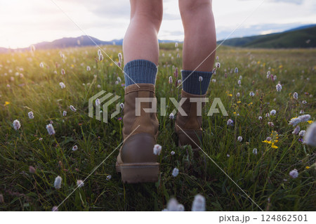Hiker legs walking on beautiful flowering grassland 124862501