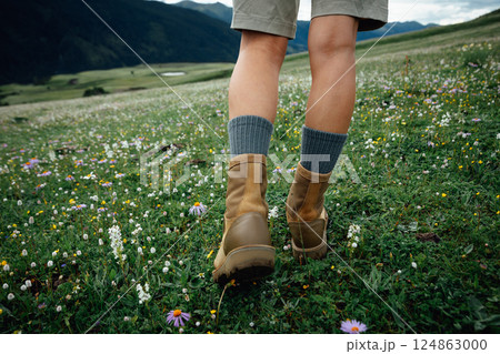 Hiker legs walking on beautiful flowering grassland Hiker legs walking on beautiful flowering grassland 124863000