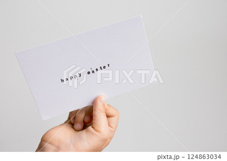 Caucasian child holding happy Easter card in hand Caucasian child holding happy Easter card in hand 124863034