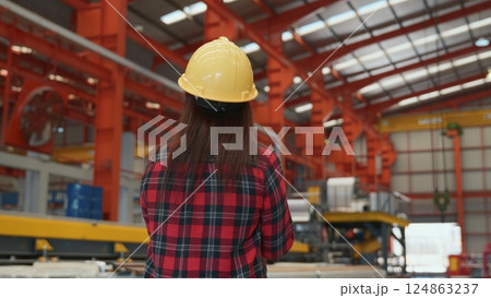 Back professional heavy Industry engineer woman worker wearing safety helmet using clipboard to checking she work production in factory industry manufacture Back professional heavy Industry engineer woman worker wearing safety helmet using clipboard to checking she work production in factory industry manufacture 124863237