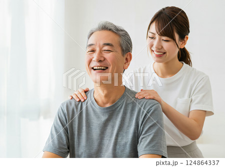 娘に肩もみをしてもらう父親 124864337