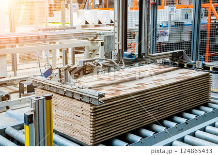 Production line of the wooden floor factory. CNC automatic woodworking machine. 124865433