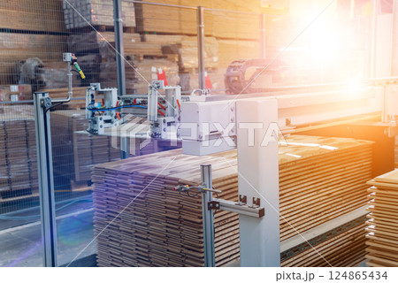 Production line of the wooden floor factory. CNC automatic woodworking machine. Production line of the wooden floor factory. CNC automatic woodworking machine. 124865434