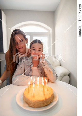 Birthday Cake Candles Family: Girl celebrates birthday with mother at home, making a wish, enjoying a special moment. Birthday Cake Candles Family: Girl celebrates birthday with mother at home, making a wish, enjoying a special moment. 124865466