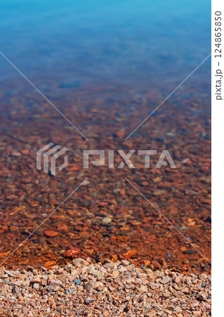 rocky beach of the Almaty reservoir. small stones on the shore of Kapchagay rocky beach of the Almaty reservoir. small stones on the shore of Kapchagay 124865850
