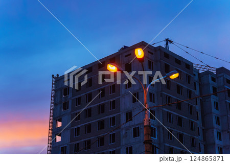 unfinished high-rise building against the backdrop of the sunset sky. building without finishing unfinished high-rise building against the backdrop of the sunset sky. building without finishing 124865871