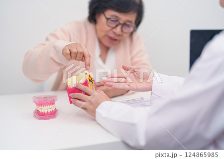 Elderly Patient consulting Dentist to Tooth disease, Senior Health Medical Diagnosis. Anatomy teeth model for Oral Teeth decay, Scrape off tartar. March Oral health, Dentist Day, False Teeth concept Elderly Patient consulting Dentist to Tooth disease, Senior Health Medical Diagnosis. Anatomy teeth model for Oral Teeth decay, Scrape off tartar. March Oral health, Dentist Day, False Teeth concept 124865985