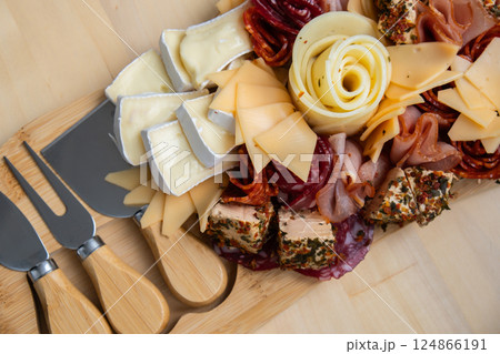 Food trend gift aperitivo party idea. Appetizers wooden grazing board with different antipasti charcuterie snacks and cheese. Assorted cheese meat platter. Disordered eating 124866191