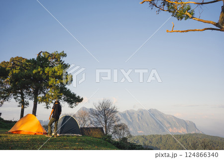 landscape and travel concept with asian man relax see sunset camping tent on mountain 124866340