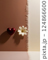 A red heart and a white flower are elegantly placed on a table 124866600