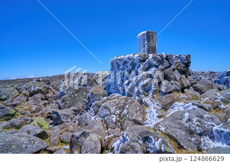 春の長野県 蓼科山の岩だらけの山頂にある方位盤を見る 124866629