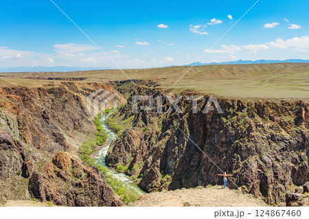girl against the backdrop of rocky mountains in the Almaty region. rocky plain in Kazakhstan girl against the backdrop of rocky mountains in the Almaty region. rocky plain in Kazakhstan 124867460