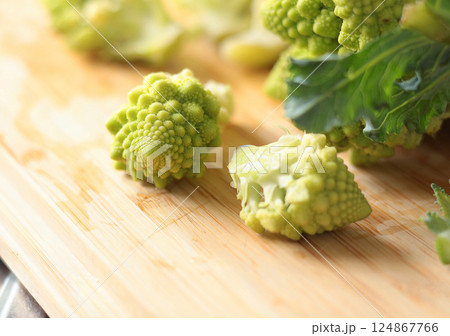 Sliced florets of Romanesco broccoli cabbage on wooden board in kitchen. Healthy eating. Food and green vegetables. 124867766