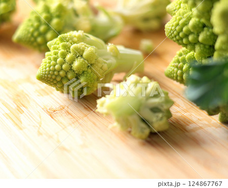 Sliced florets of Romanesco broccoli cabbage on wooden board in kitchen. Healthy eating. Food and green vegetables. 124867767