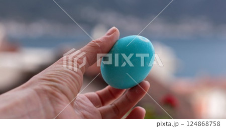 Turquoise Easter eggs coloring activity with bright turquoise egg decorated in a scenic outdoor setting during Easter celebration 124868758