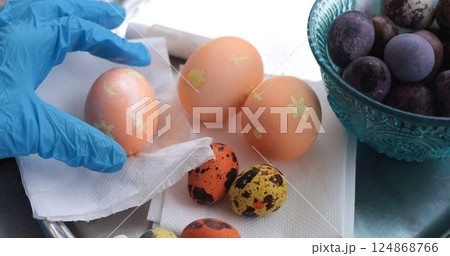 Coloring Easter eggs with pearl paint and decorating eggs in vibrant colors for holiday fun 124868766