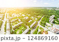 Aerial city view with crossroads and roads, houses, buildings, parks and parking lots. Sunny summer panoramic image 124869160
