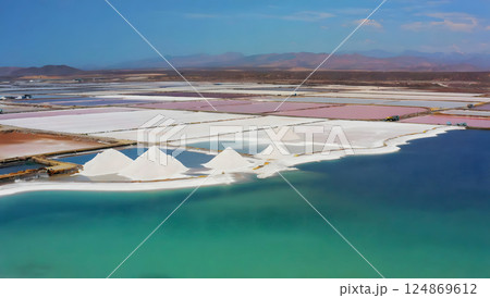 Sea salt production site showing treatment machinery, equipment, and stockpiled salt ready for packaging. 124869612