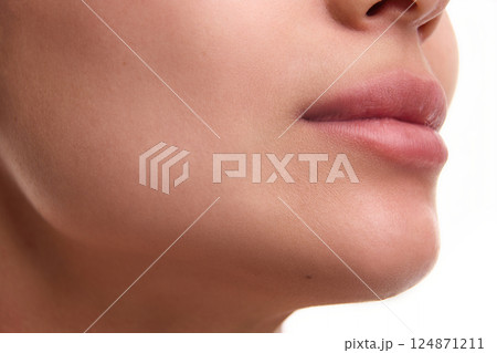 Cropped close-up image of beautiful female spotless face with plump pink lips, perfect chin line. Aesthetic ideals, lifting, plastic surgery, facial contouring 124871211