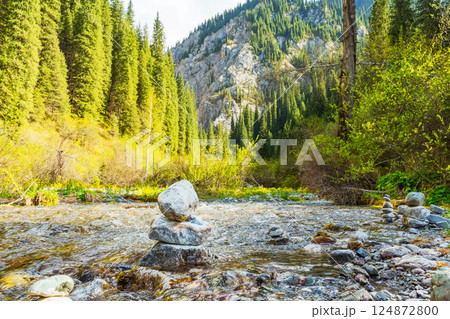 pyramid of river stones on the river bank. A tower of stones in the forest 124872800