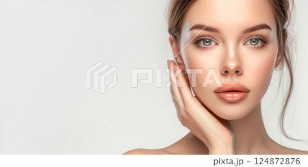Beautiful young woman with fresh clean skin on white background with copy space. Face care, cosmetology, beauty treatment and spa concept. 124872876