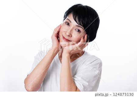頬に手をあてて微笑む黒髪ショートヘアーの中年女性 頬に手をあてて微笑む黒髪ショートヘアーの中年女性 124873130