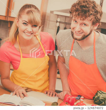 Couple cooking in kitchen reading cookbook Couple cooking in kitchen reading cookbook 124874872