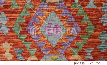 Manufacturing process, weaving of a traditional wool oriental red carpet with an intricate floral pattern, decorative elements 124875502