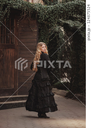 Elegant woman in Victorian black corset turns with steady gaze beneath ivy archway, surrounded by shadows and old wood. Perfect for historical , fantasy cover. Elegant woman in Victorian black corset turns with steady gaze beneath ivy archway, surrounded by shadows and old wood. Perfect for historical , fantasy cover. 124875524