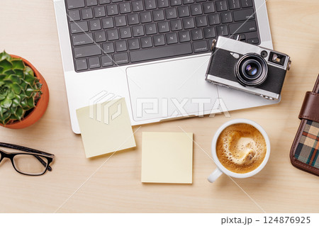 A workspace setup featuring a laptop and blank paper notes 124876925
