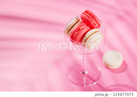 A delightful assortment of colorful macaroons arranged on a vibrant pink background 124877073