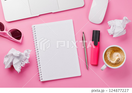 Top view of a pink desk with office supplies, coffee cup, and blank notepad Top view of a pink desk with office supplies, coffee cup, and blank notepad 124877227