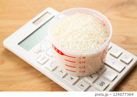 計量カップに入った米と電卓 計量カップに入った米と電卓 124877364