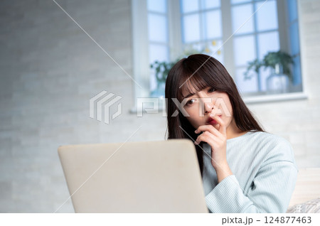 パソコンを見て悩む若い女性 124877463