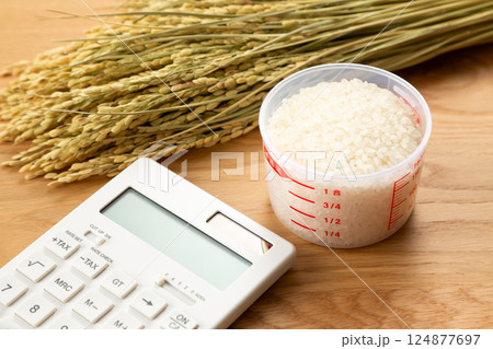 計量カップに入った米と電卓 124877697