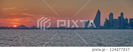 Doha, Qatar-March 21, 2025: Doha Qatar skyline from the Corniche street at dusk with dhows in the Arabic gulf in the foreground Doha, Qatar-March 21, 2025: Doha Qatar skyline from the Corniche street at dusk with dhows in the Arabic gulf in the foreground 124877837