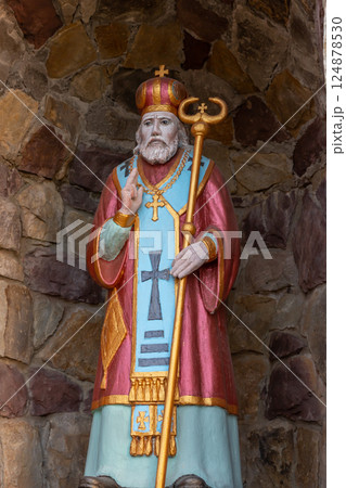 Colorful statue of a saint wearing a crown and holding a staff in a stone alcove in a historical site during daylight Colorful statue of a saint wearing a crown and holding a staff in a stone alcove in a historical site during daylight 124878530