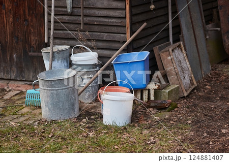 Buckets and tools by the shed on a farmstead backyard 124881407