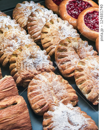 Freshly baked pastries arranged neatly in a display case at a local bakery during the morning hours Freshly baked pastries arranged neatly in a display case at a local bakery during the morning hours 124881740