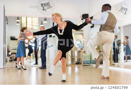 Woman pensioner with african man practising charleston Woman pensioner with african man practising charleston 124881799