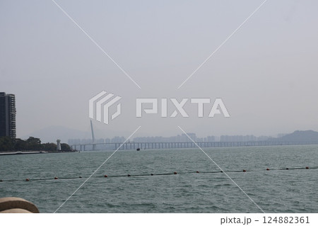 空と海の向こうに橋と香港の街並みの見える深圳の海岸からの風景 124882361