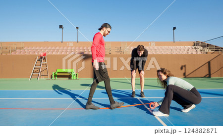 Group of young adult friends converting a Tennis court to a Pickleball 124882871