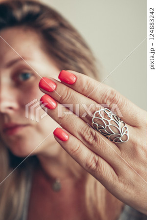 Beautiful mid age woman showing red shellac manicure on nails . Beautiful mid age woman showing red shellac manicure on nails . 124883242