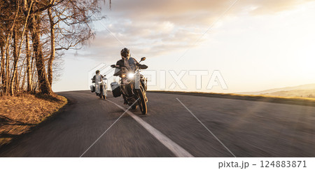 Two Drivers Riding Motorcycle on Empty Road During Sunset. 124883871